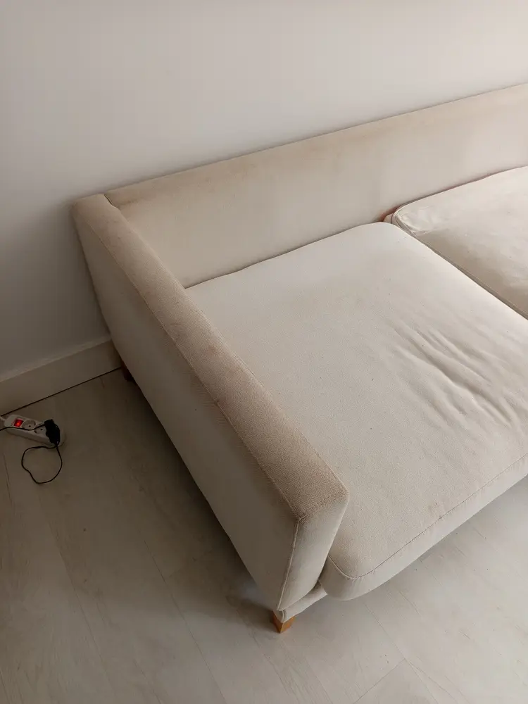 Sofá de tela blanca con manchas antes de la limpieza